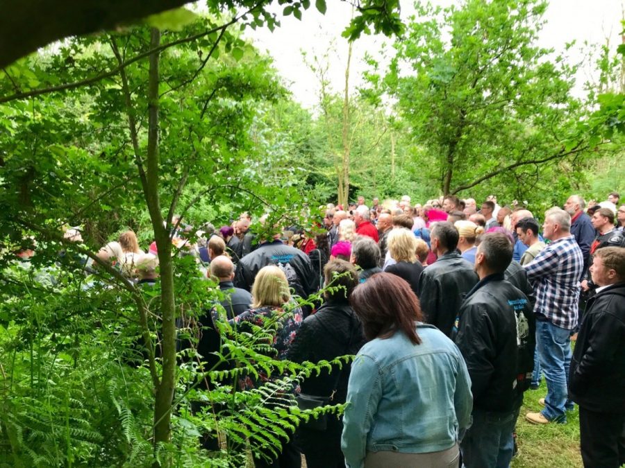 Crowd gathered at Respect woodland green burials for funeral service.