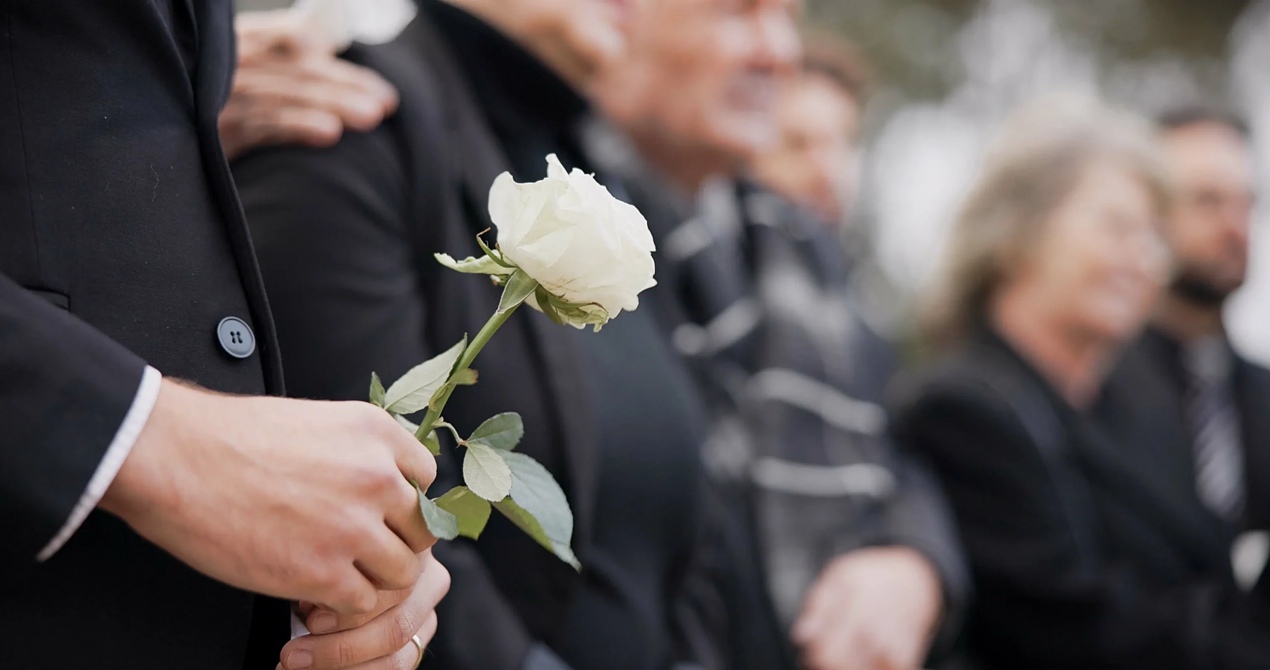 Loved ones gathered with a white rose at Respect GB cremation services.