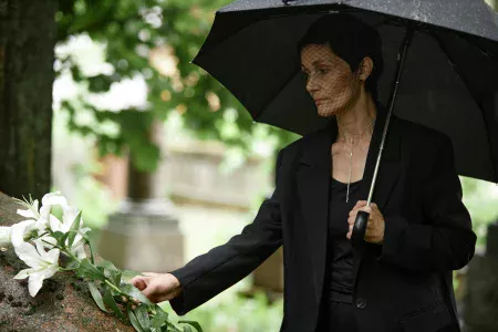 Short dark haired lady in appropriate funeral attire for women with mourning veil.