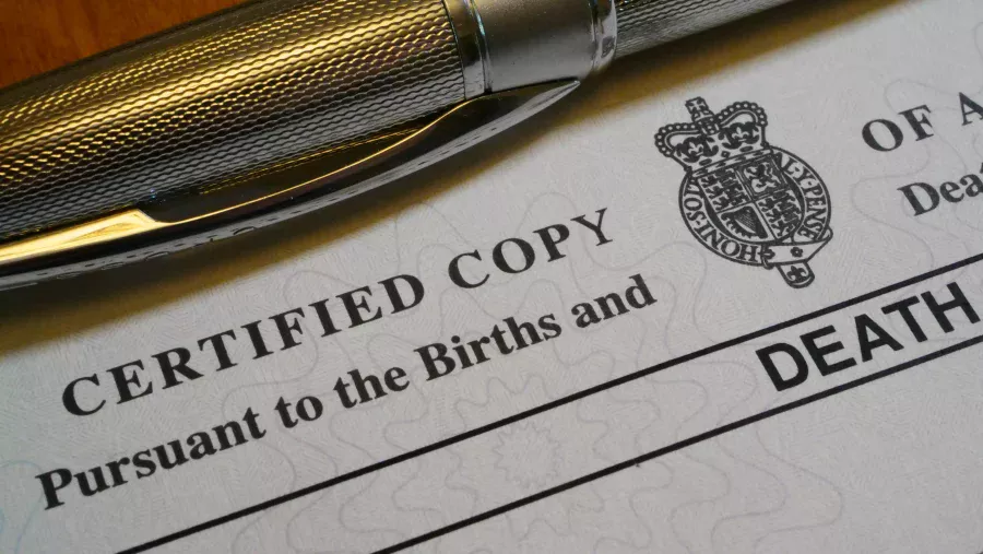 UK death certificate paperwork with pen